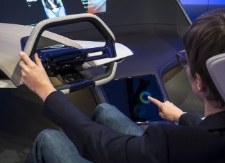Cómo afecta a la ciberseguridad de tu coche todo lo que le conectas Imagen de una persona al volante de un BMW del futuro