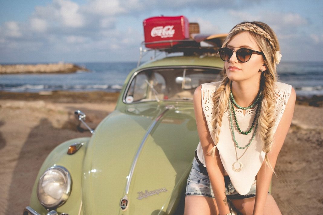 UNa chica está apoyada en su Volkswagen Escarabajo