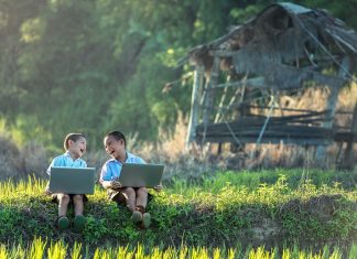 Vídeo: Juegos para que los niños aprendan de tecnología Dos niños con ordenadores en medio de un campo