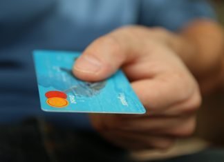 Nuestros datos bancarios online, ¿más blindados que nunca? Primer plano de una tarjeta de crédito azul sostenida por una mano
