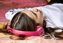 Día Mundial de las tiendas de discos: ¿Qué música escuchan los hackers mientras conducen? Imagen de una chica tumbada escuchando música con unos cascos