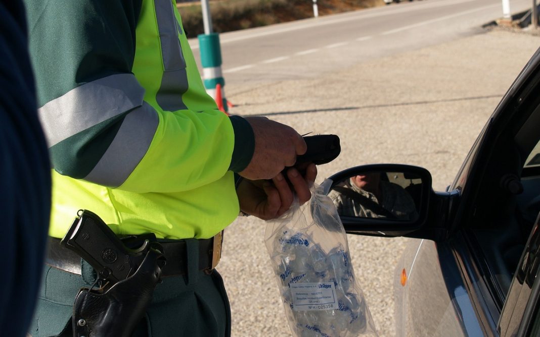 Imagen de un guardia civil junto a un vehículo