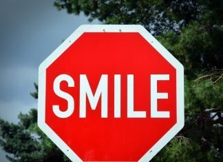 ¿Pagarías una multa de tráfico con… tu tiempo? Señal de STOP que en vez de poner dicha palabra pone "SMILE".