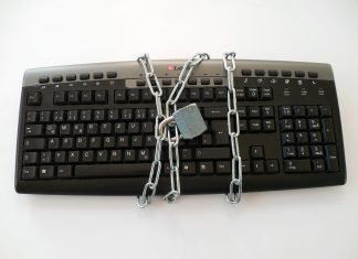 ¿Qué pasará con tus contraseñas cuando mueras? Teclado de ordenador rodeado por una cadena cerrada por un candado