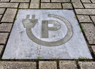 ¿Pueden los coches eléctricos boicotear elecciones? Imagen en el suelo que identifica una plaza para recargar coches eléctricos.