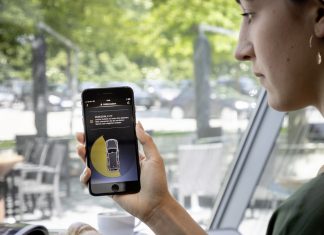 Top 5: los cinco coches conectados del año Imagen de una mujer consultando el estado del coche en su teléfono móvil