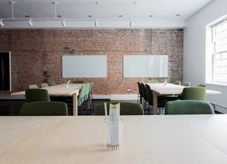 Te forman, te buscan trabajo y lo pagas cómodamente Imagen de un aula con sus pupitres y pizarra
