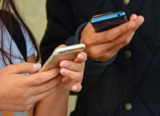 No: ningún SMS te dará 700€ en ayudas por el COVID-19 Imagen de dos personas utilizando el móvil