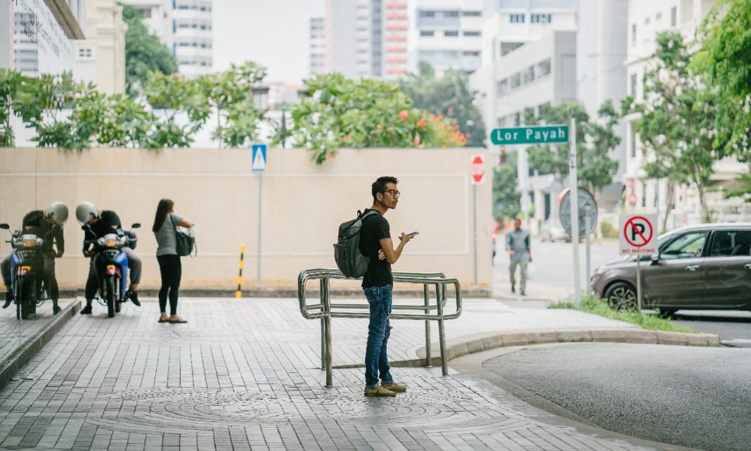 Reducir huella carbono: un hombre espera en el exterior de una estación de transporte público