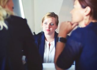El ataque de phishing que debería preocupar a los directivos de las marcas Imagen de una mujer con pinta de ejecutiva sentada en una mesa delante de dos personas de las que solo se ve un hombro