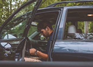 Todos los coches multados por incumplir la Ley de Protección de Datos Imagen de un coche aparcado con la puerta del conductor abierta y con un joven sentado en el puesto del conductor mirando hacia abajo