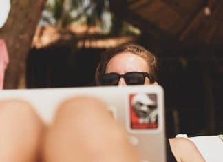 Qué ciberconsejos debes aplicar si trabajas online para una marca de coches mujer trabajando con ordenador en la playa