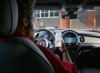 Cómo usar Bluetooth en un vehículo de alquiler de una forma cibersegura Imagen de una persona que vincula su móvil al coche por Bluetooth