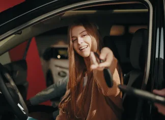 ¿Qué cíber-consejos aplicar en tu nuevo auto para tenerlo protegido desde el primer minuto? UNa persona estrena sonriente su vehículo
